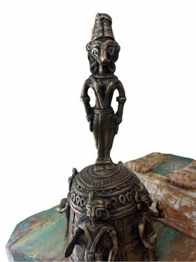 A handcrafted brass ritual bell with tribal musicians. W Bengal
